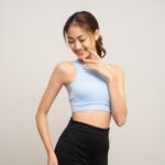 Smiling woman in activewear with a toned midsection representing a confident Quantum RF candidate who has achieved body contouring results