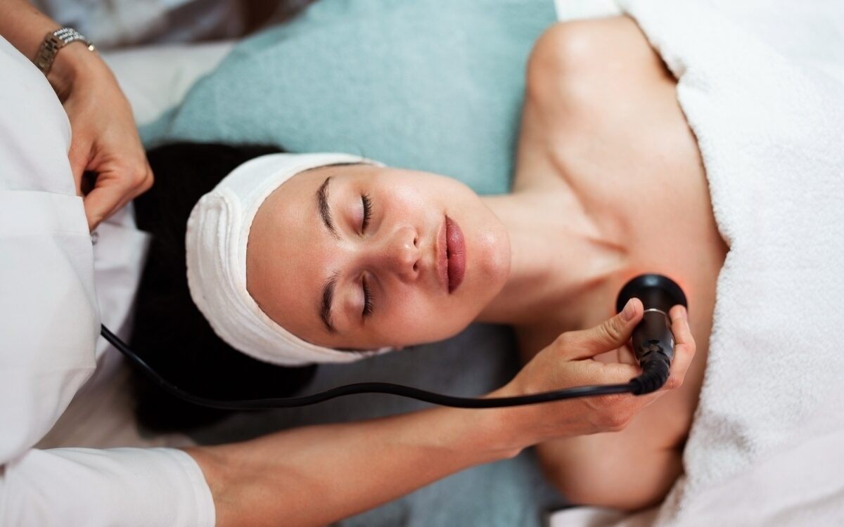 Patient lying with eyes closed in complete comfort during a Quantum RF pain-free radiofrequency treatment on the neck and jaw area at a professional aesthetic clinic