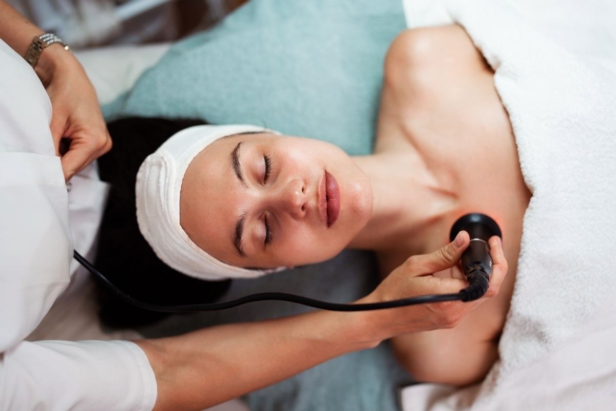 Patient lying with eyes closed in complete comfort during a Quantum RF pain-free radiofrequency treatment on the neck and jaw area at a professional aesthetic clinic