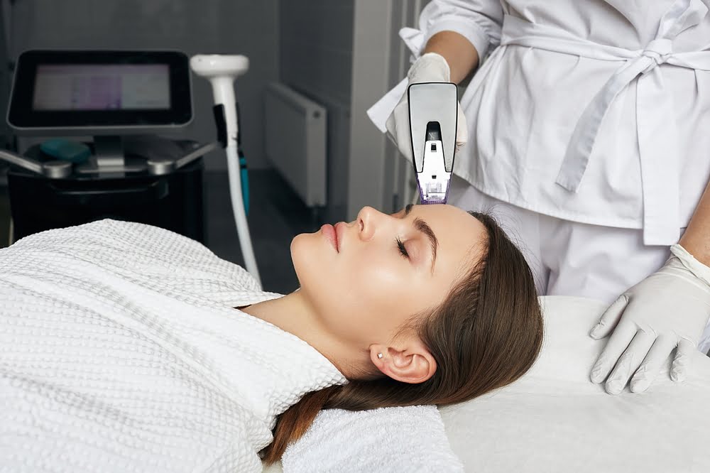 Provider applying Morpheus8 RF microneedling handpiece to patient forehead for Morpheus8 treatment in Flower Mound TX at Medi-Elite Health and Wellness